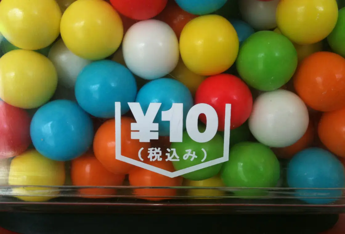 Close-up of glossy multicoloured gumballs in a candy machine